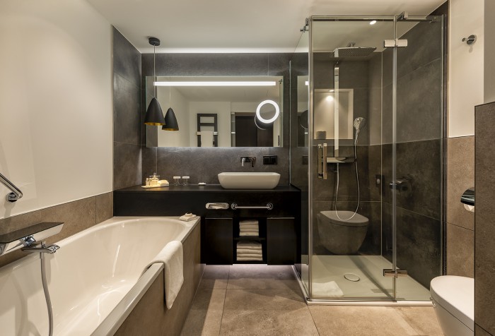 Badezimmer des Business Premium Zimmers im Hotel Palace Berlin mit Badewanne, Dusche und Toilette in modernen Grau- und Brauntönen.
