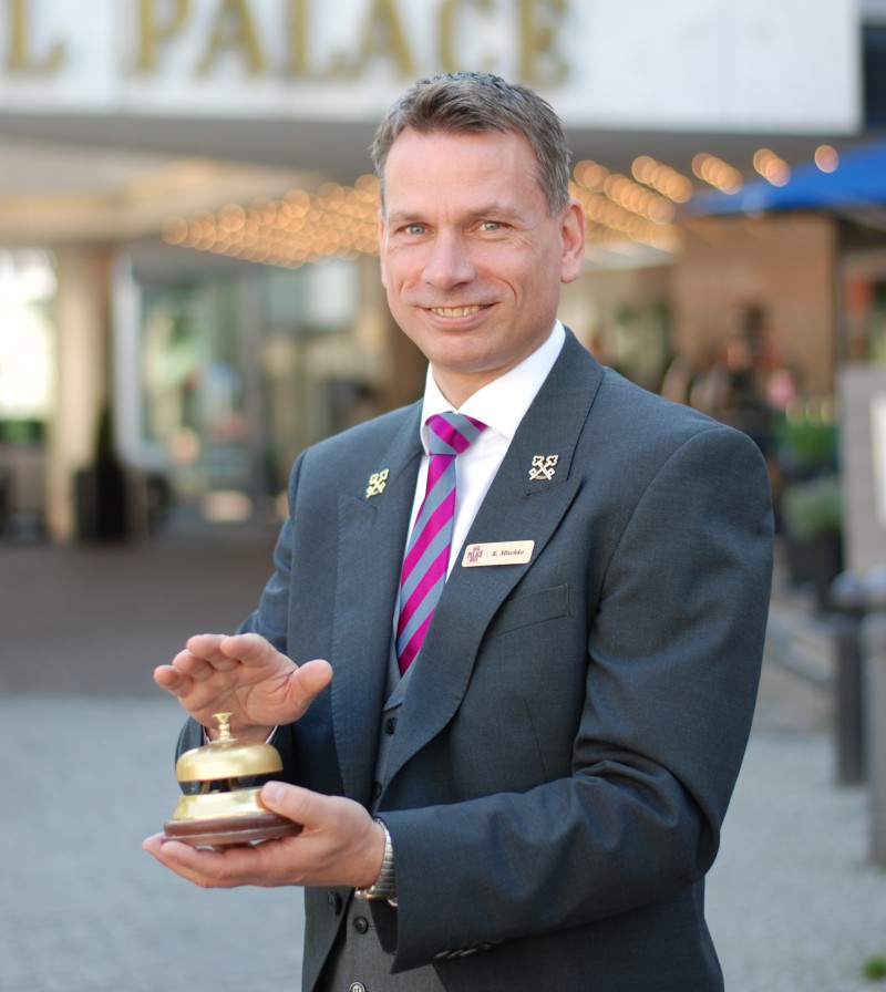 Ein Foto von Chef Concierge Kay Mischke vor dem Eingang des Hotel Palace Berlin.