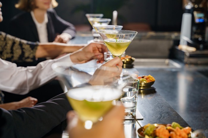 Gäste genießen ein Gin-Tasting in der House of Gin Bar im Hotel Palace Berlin. Verschiedene Gin-Gläser stehen auf dem Tisch, während die Gäste die Aromen in stilvoller Atmosphäre probieren.
