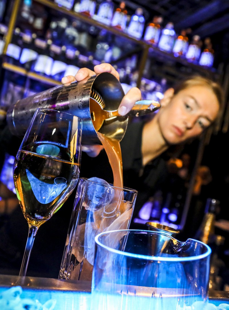 Barkeeper füllt ein Glas während Silvesterparty im House of Gin Berlin.