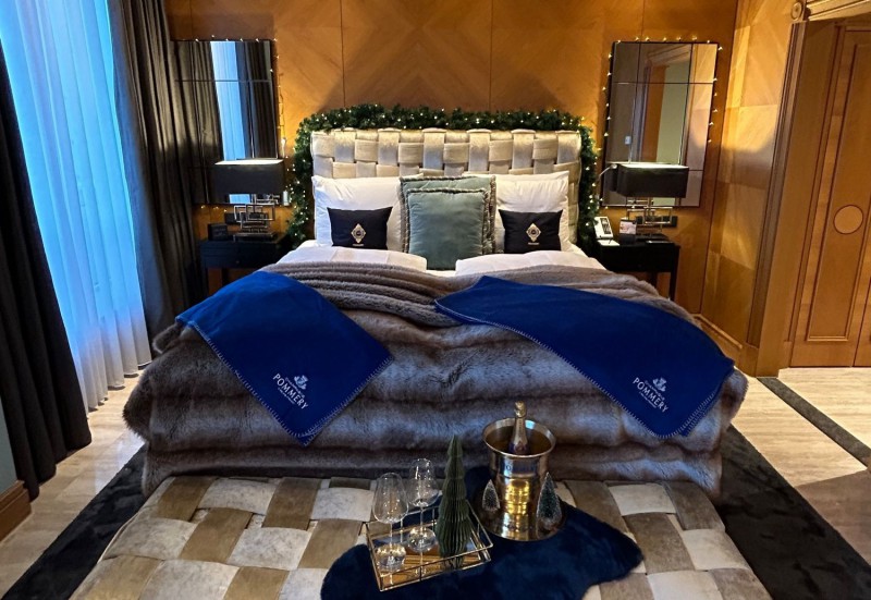 Schlafzimmer in der Pommery Weihnachts-Park Suite festlich geschmückt mit Pommery-Champagner und Dekoration.