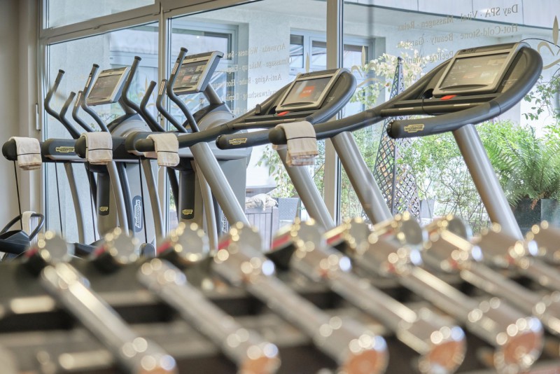 Fitness Center im Hotel Palace Berlin. Hanteln und Laufbänder vor großer Fensterfront.